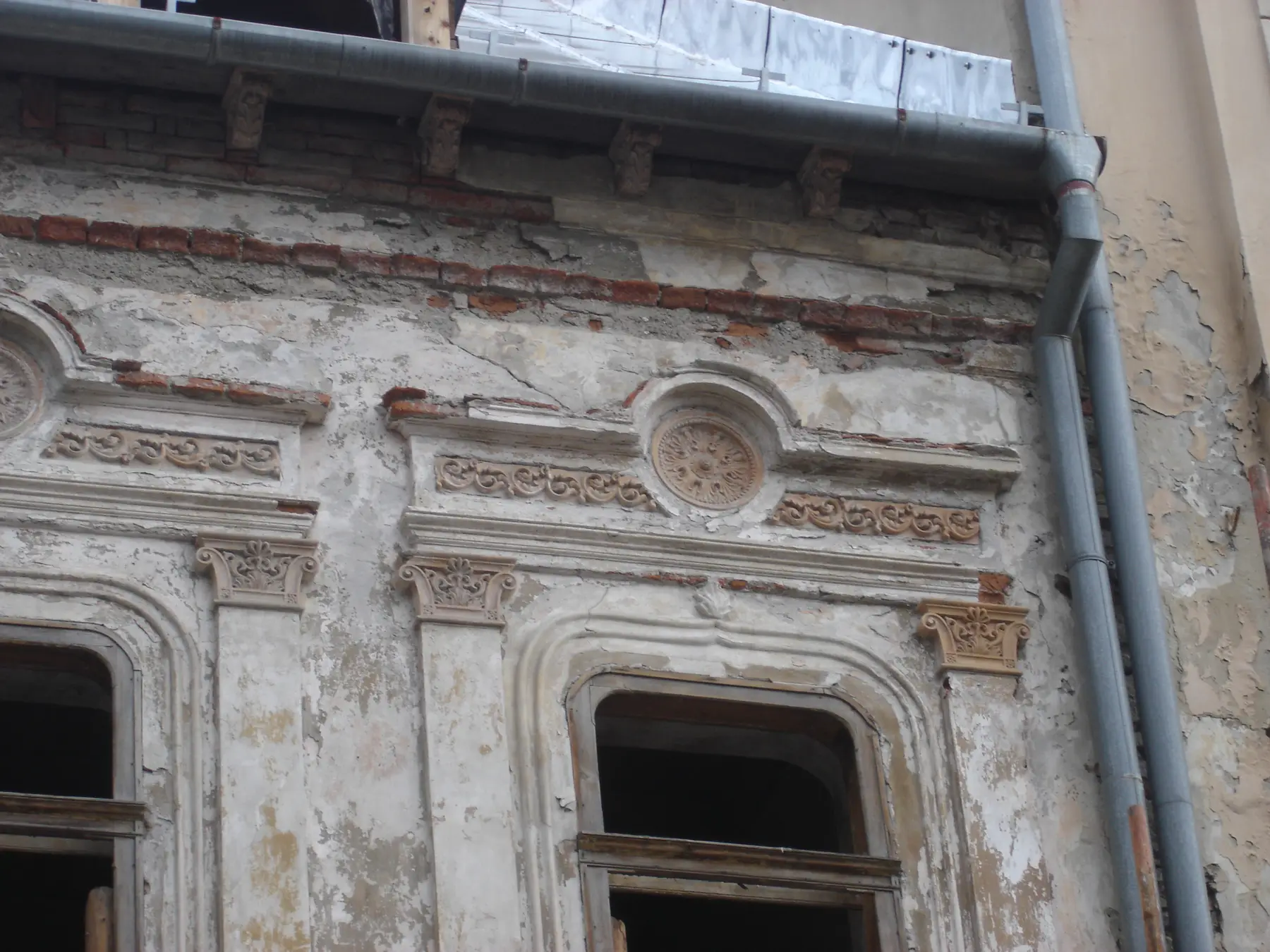 Poškodená štuková výzdoba okolo okna
