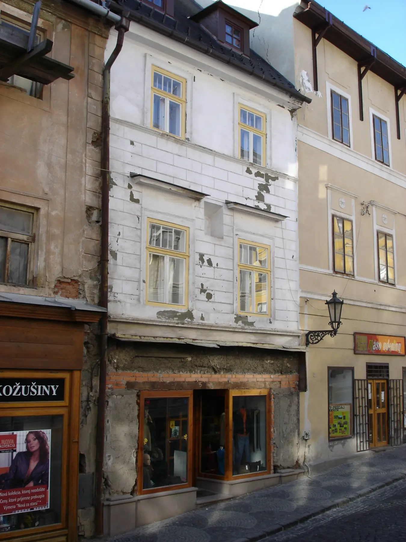 Fasáda pred obnovou s poškodenou omietkou