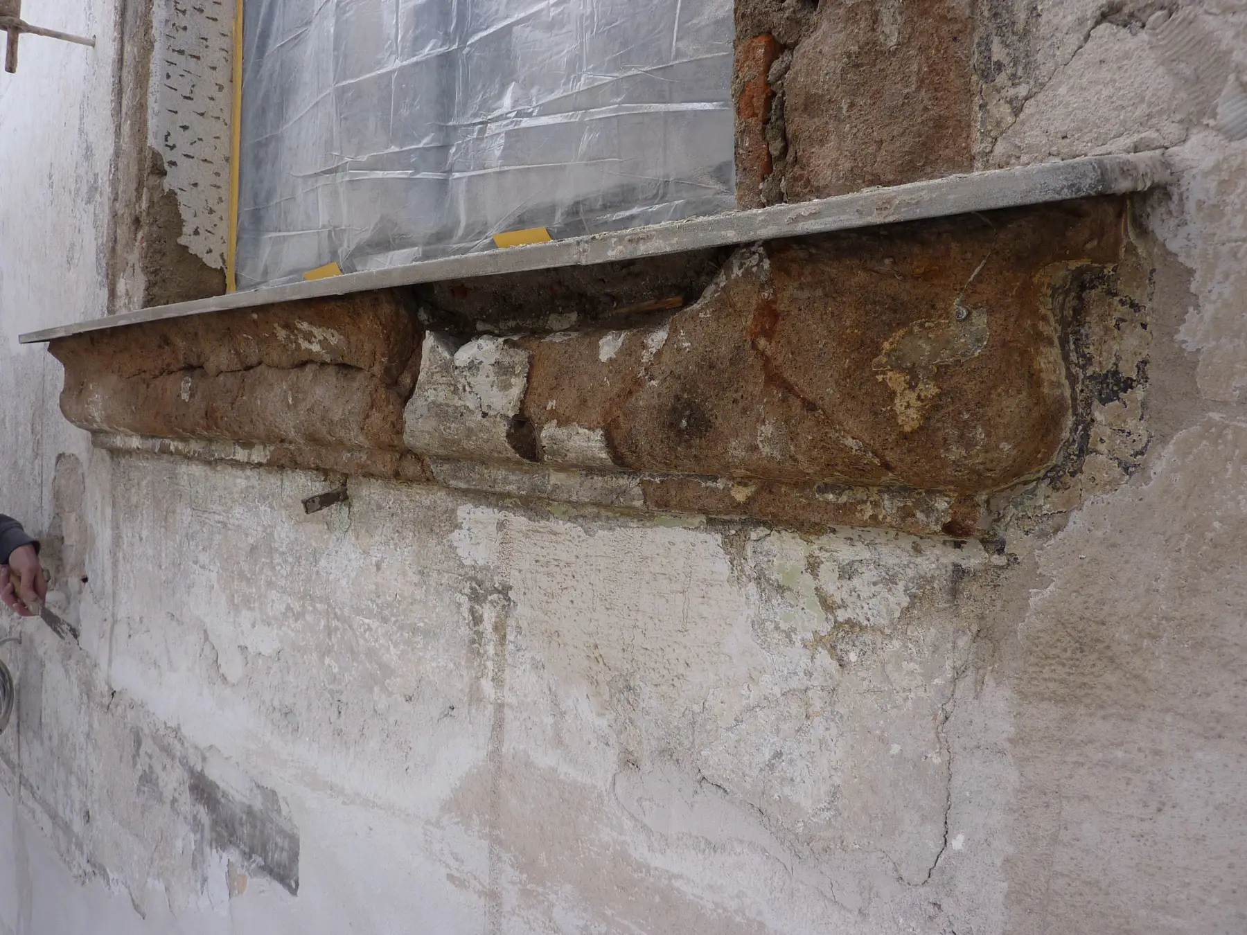 Stucco cornice uncovered above a window